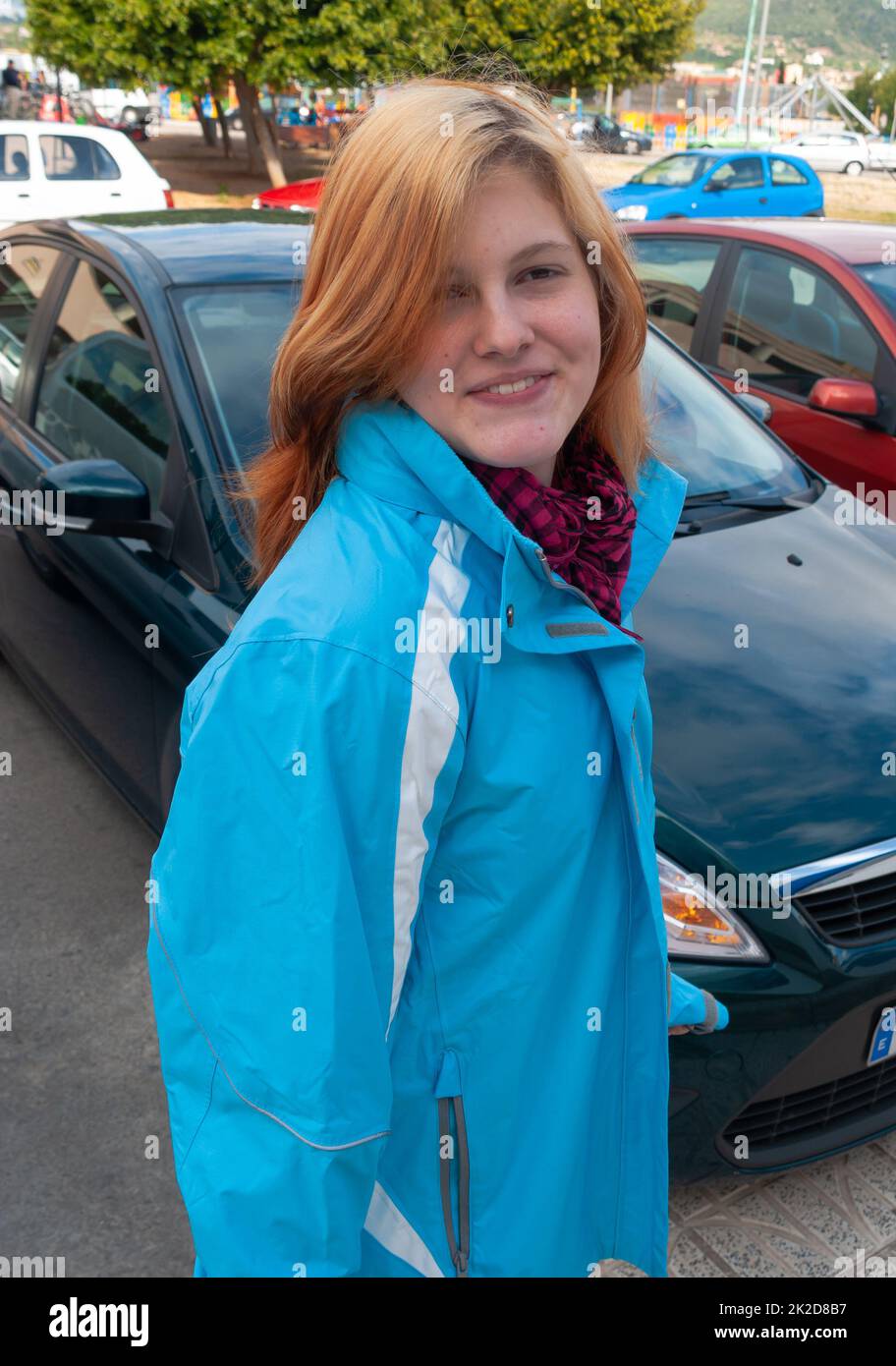 Woman with orange hair smiling at camera, car rental majorca Stock Photo
