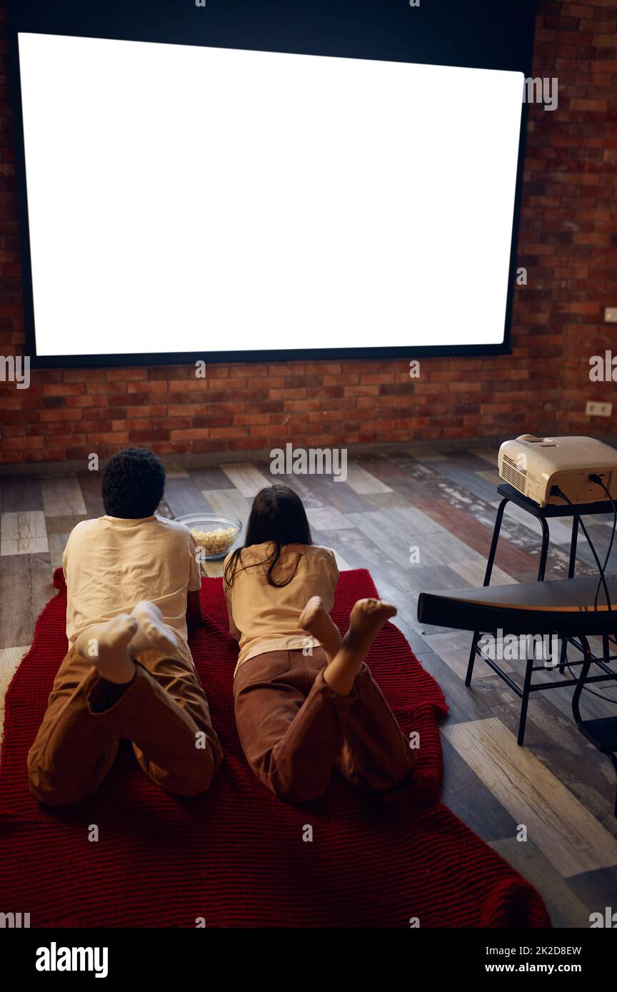 Family couple looking at blank projector screen Stock Photo