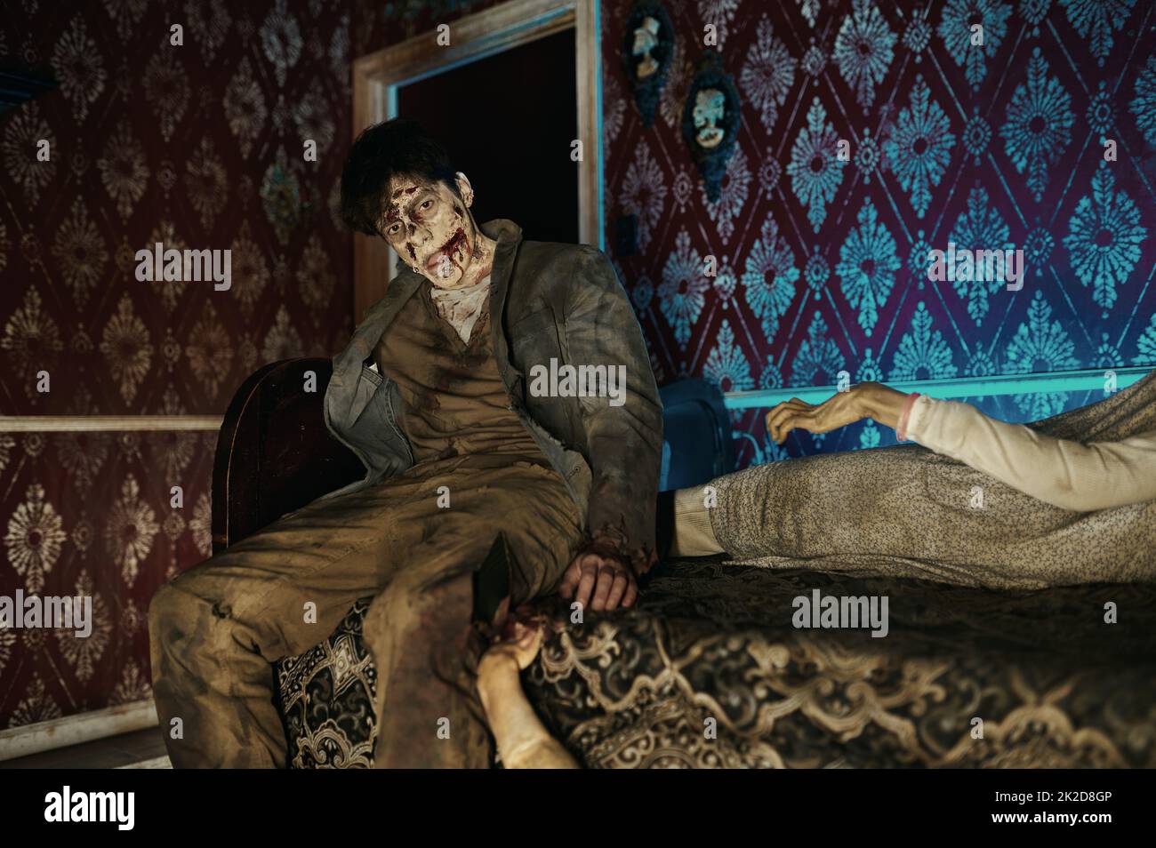 Zombie sitting on bed looking at camera Stock Photo