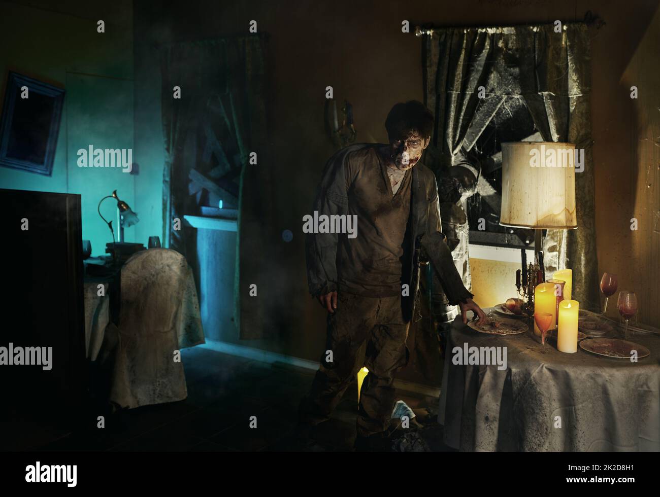 Eerie zombie man standing near dining table Stock Photo