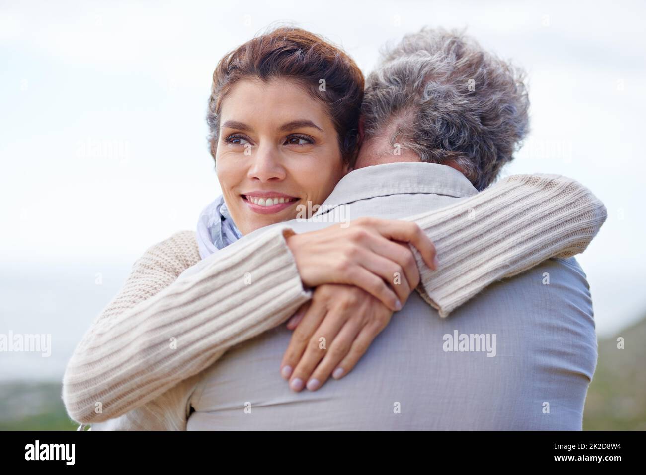 So much love after so many years. Rearview shot of a mature man being hugged by his wife. Stock Photo