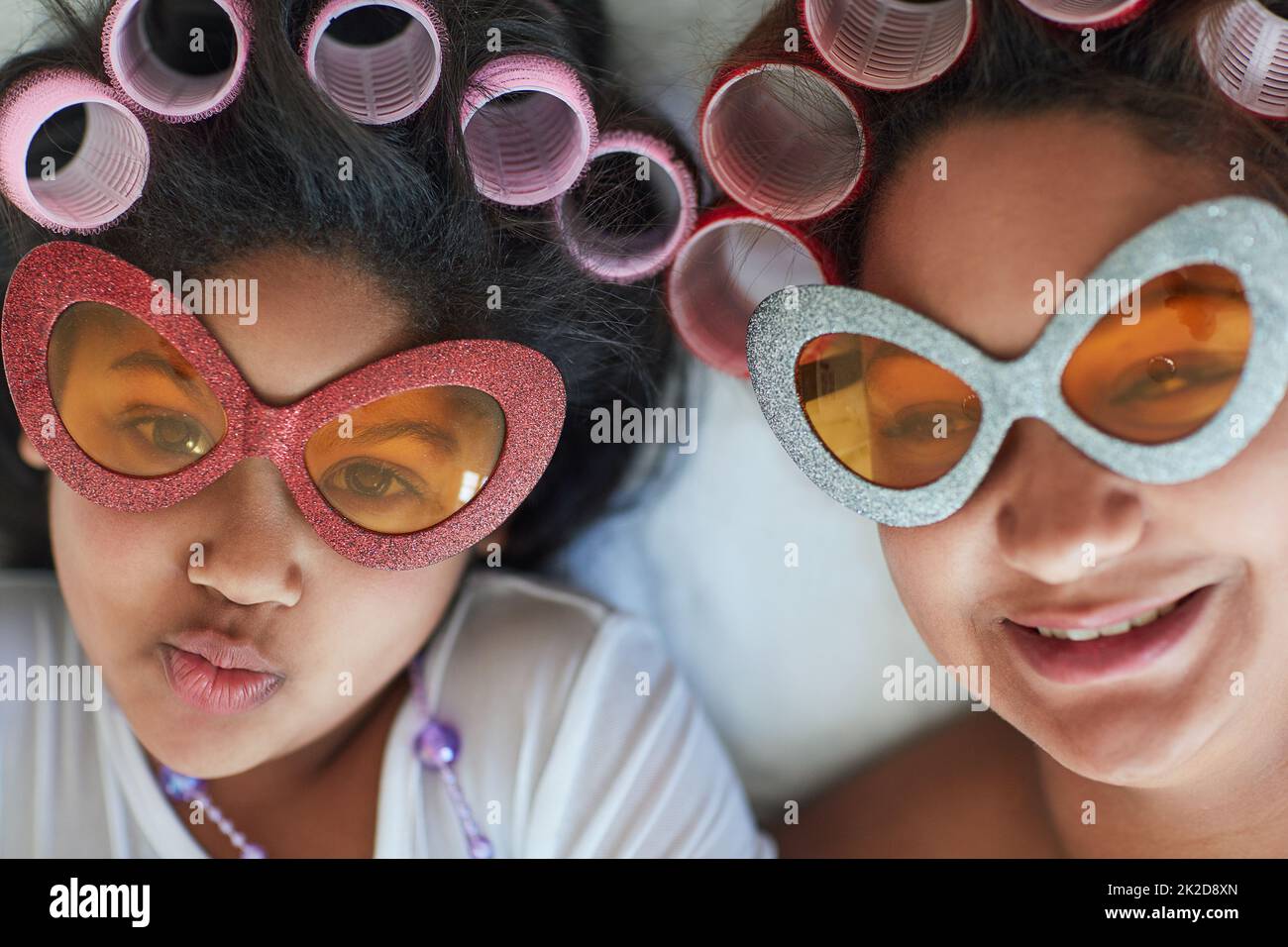 Were feeling fabulous. Portrait of a mother and her little girl wearing sunglasses and curlers at home. Stock Photo