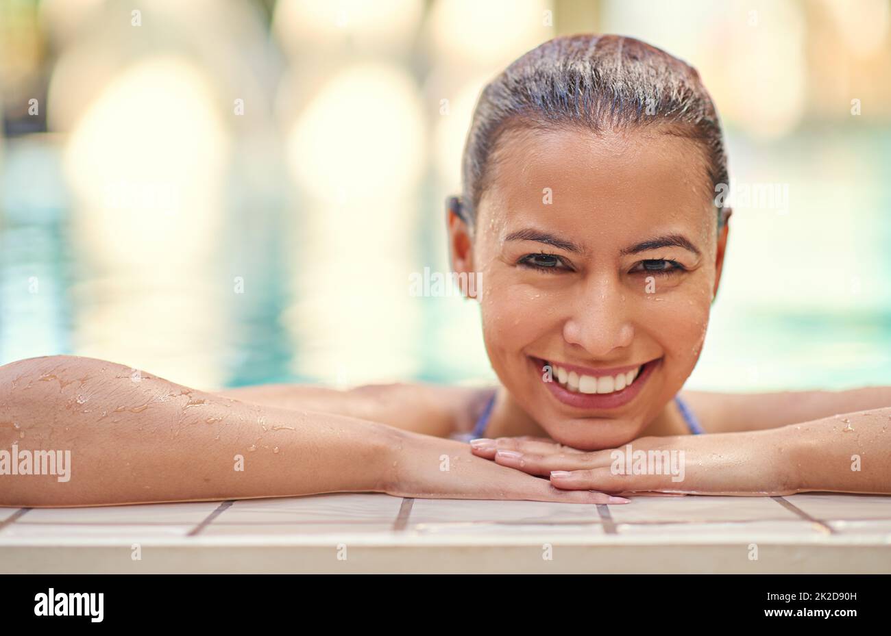 Youre only one swim away from a good mood. Shot of a young woman relaxing in the pool at a spa. Stock Photo