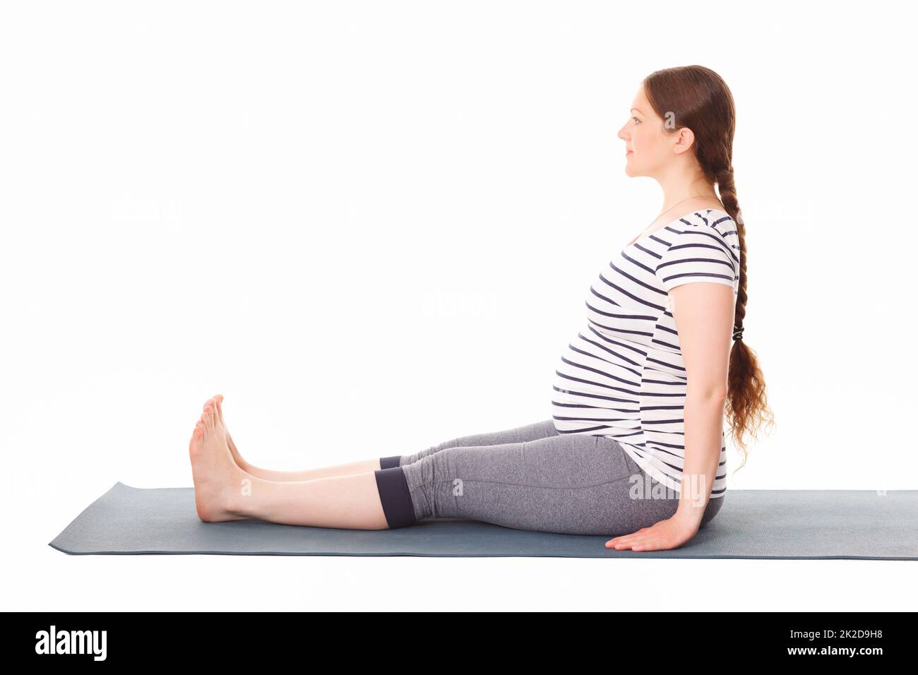 Pregnant woman doing yoga asana Dandasana Stock Photo