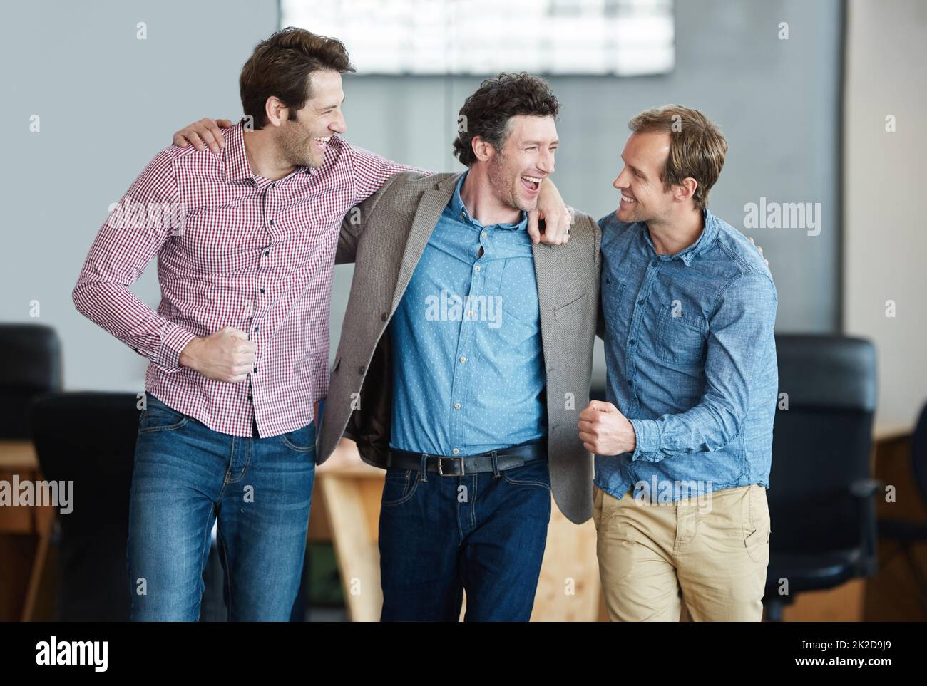 Heres to acing another project. a group of laughing coworkers standing