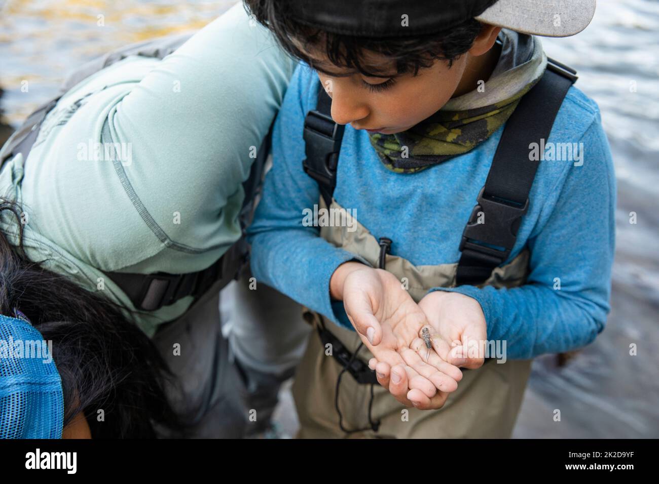 Boy on fishing trip holding insect Stock Photo