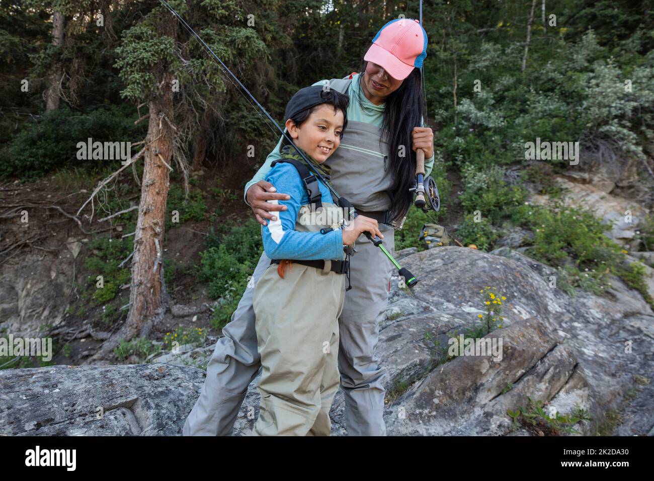 Mother and son holding fishing rods and smiling Stock Photo
