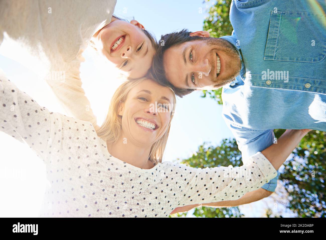 Love makes a family. Portrait of a family of three looking down at the camera. Stock Photo