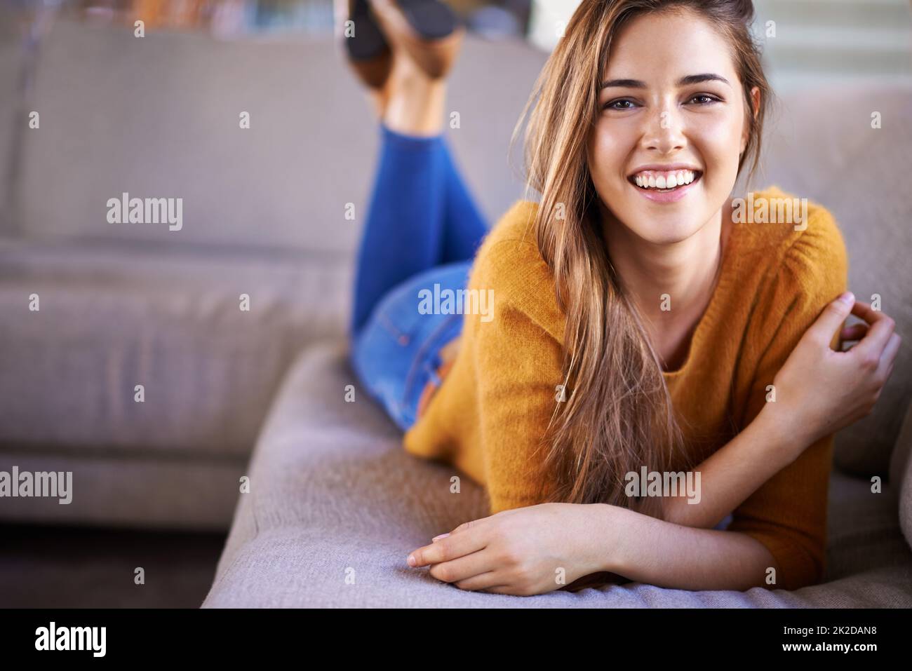 Nowhere more relaxing than on the sofa.... Portrait of a beautiful young woman lying on a sofa at home. Stock Photo