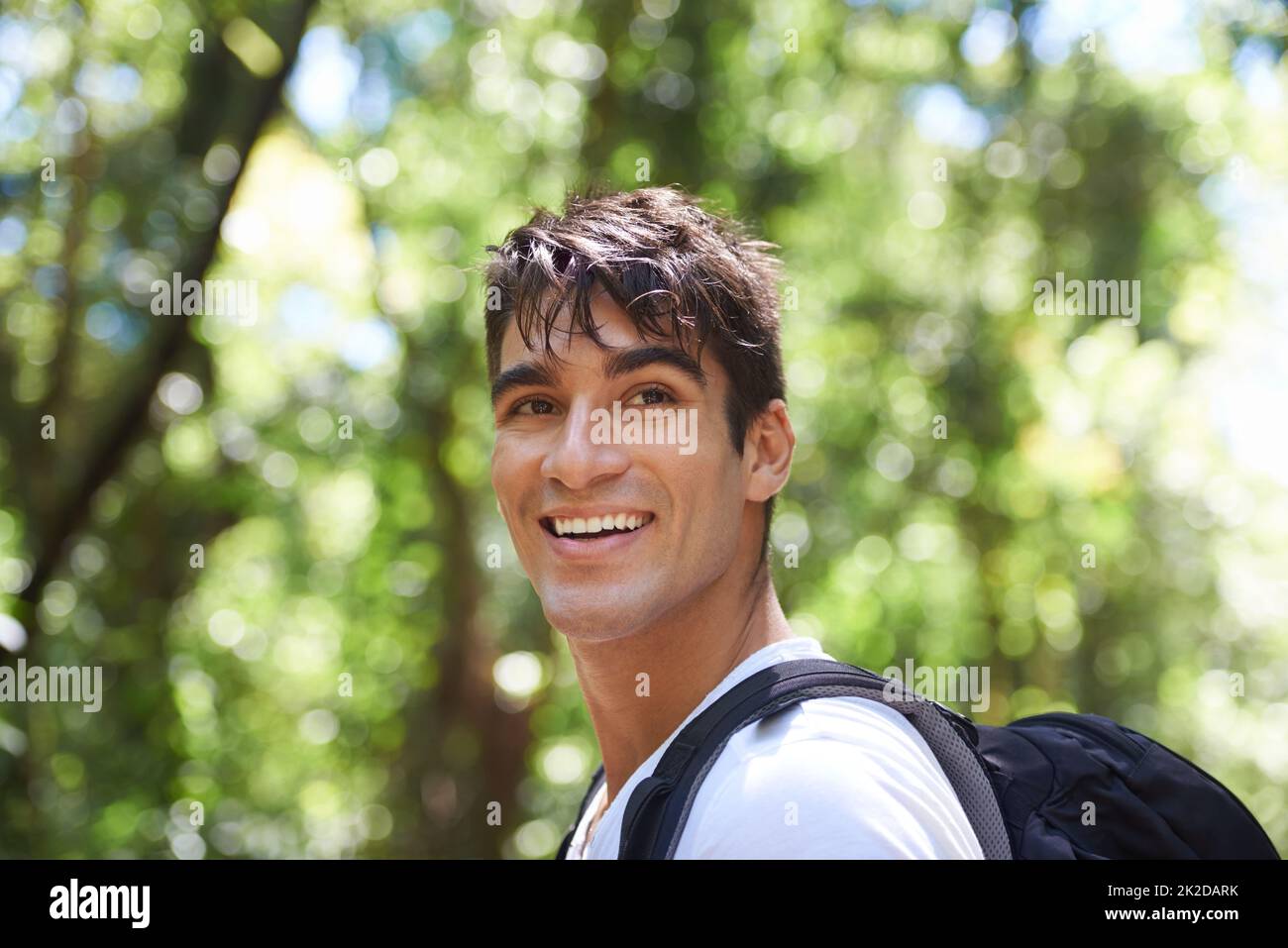 Surrounded by natures beauty. Shot of a handsome young man hiking in the forest. Stock Photo