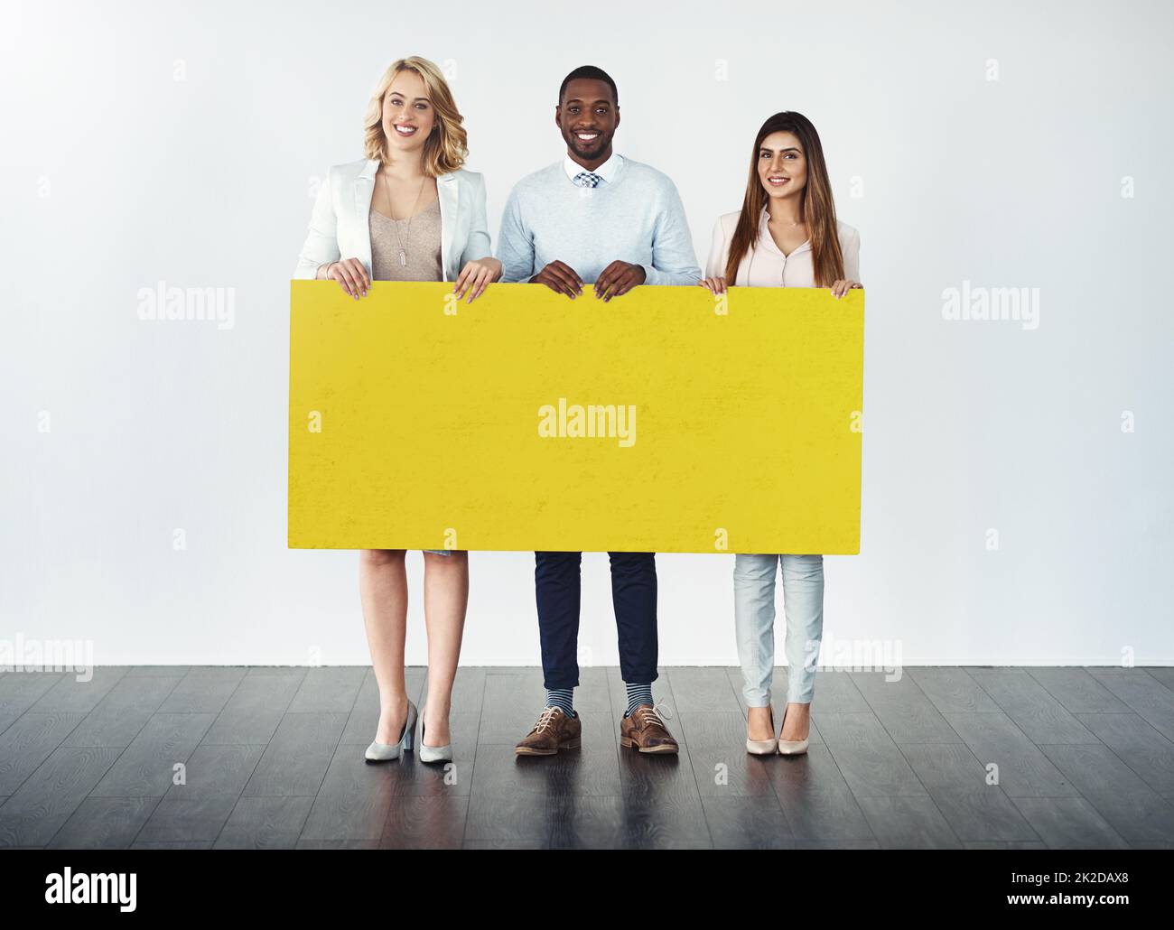 Well carry your message across. Studio shot of a group of businesspeople holding up a blank yellow placard. Stock Photo