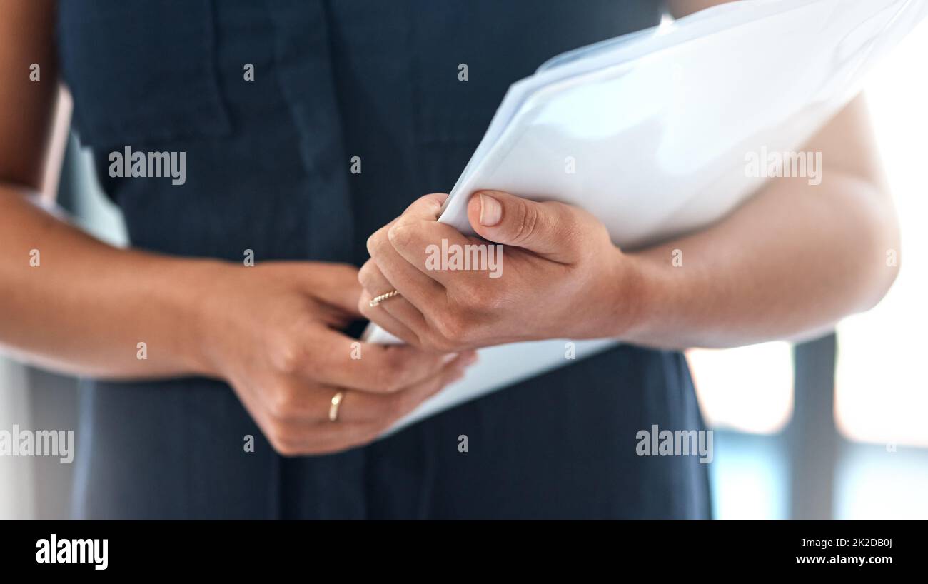 Staying organised for her busy day ahead. Closeups shot of an unrecognisable businesswoman holding paperwork in an office. Stock Photo