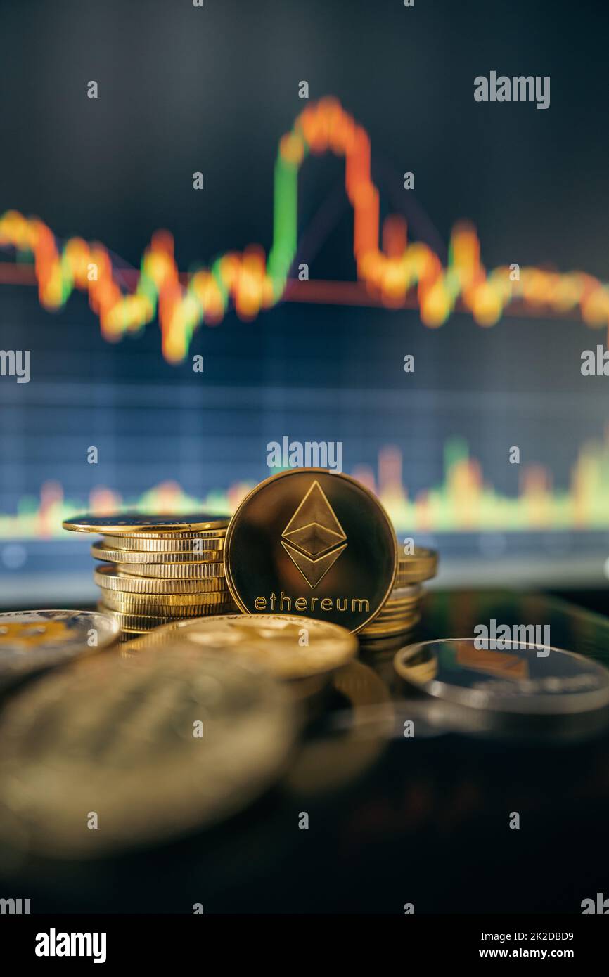 Stack or heap of gold Ethereum cryptocurrency with candle stick graph chart and digital background. Stock Photo