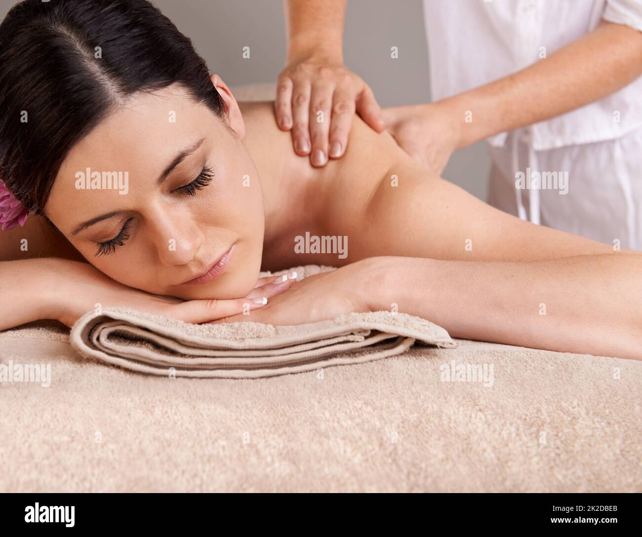 Taking time out for herself. Relaxed young woman receiving a massage at a day spa. Stock Photo