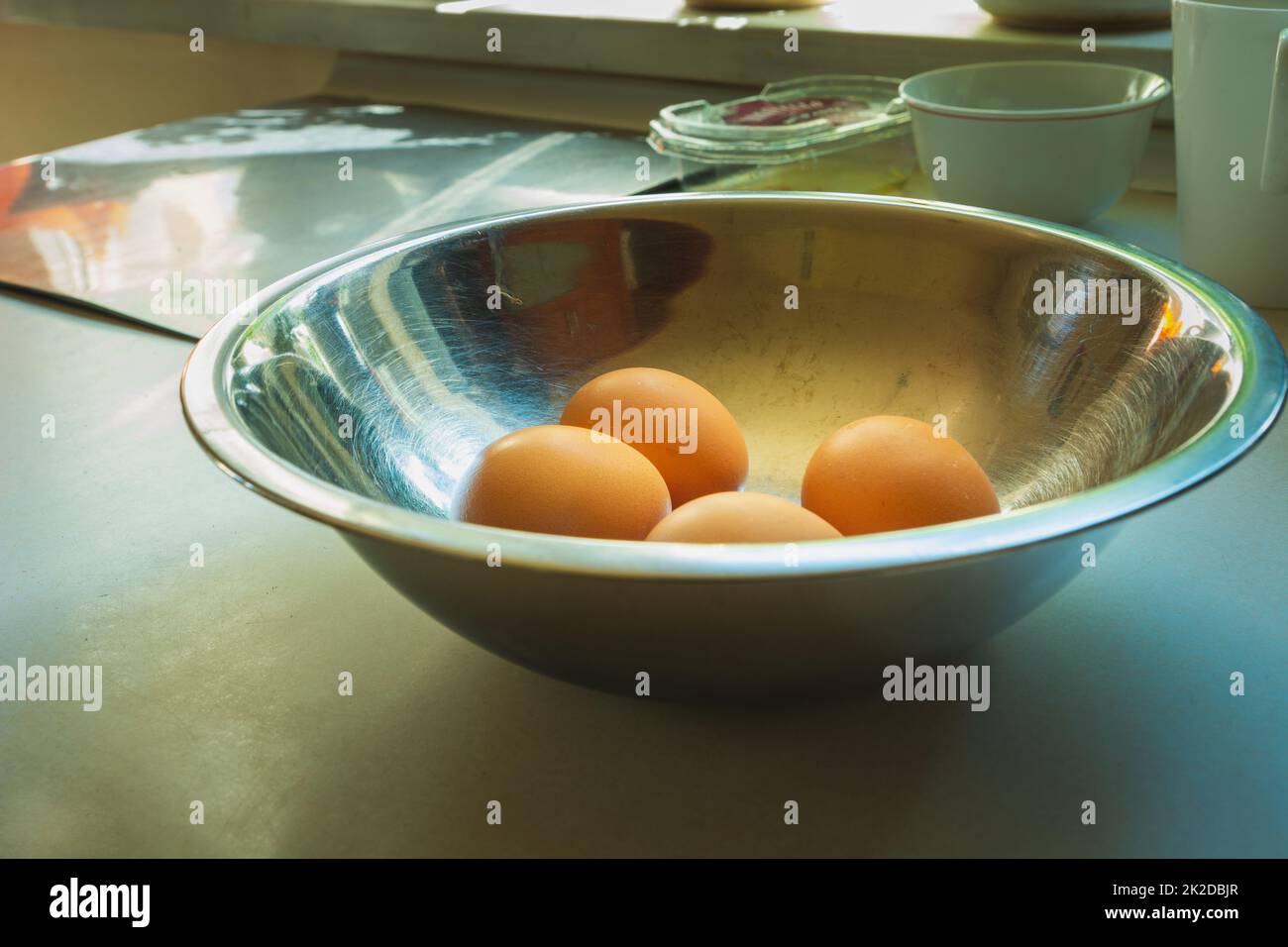 Chicken eggs in an aluminum bowl on the countertop Stock Photo