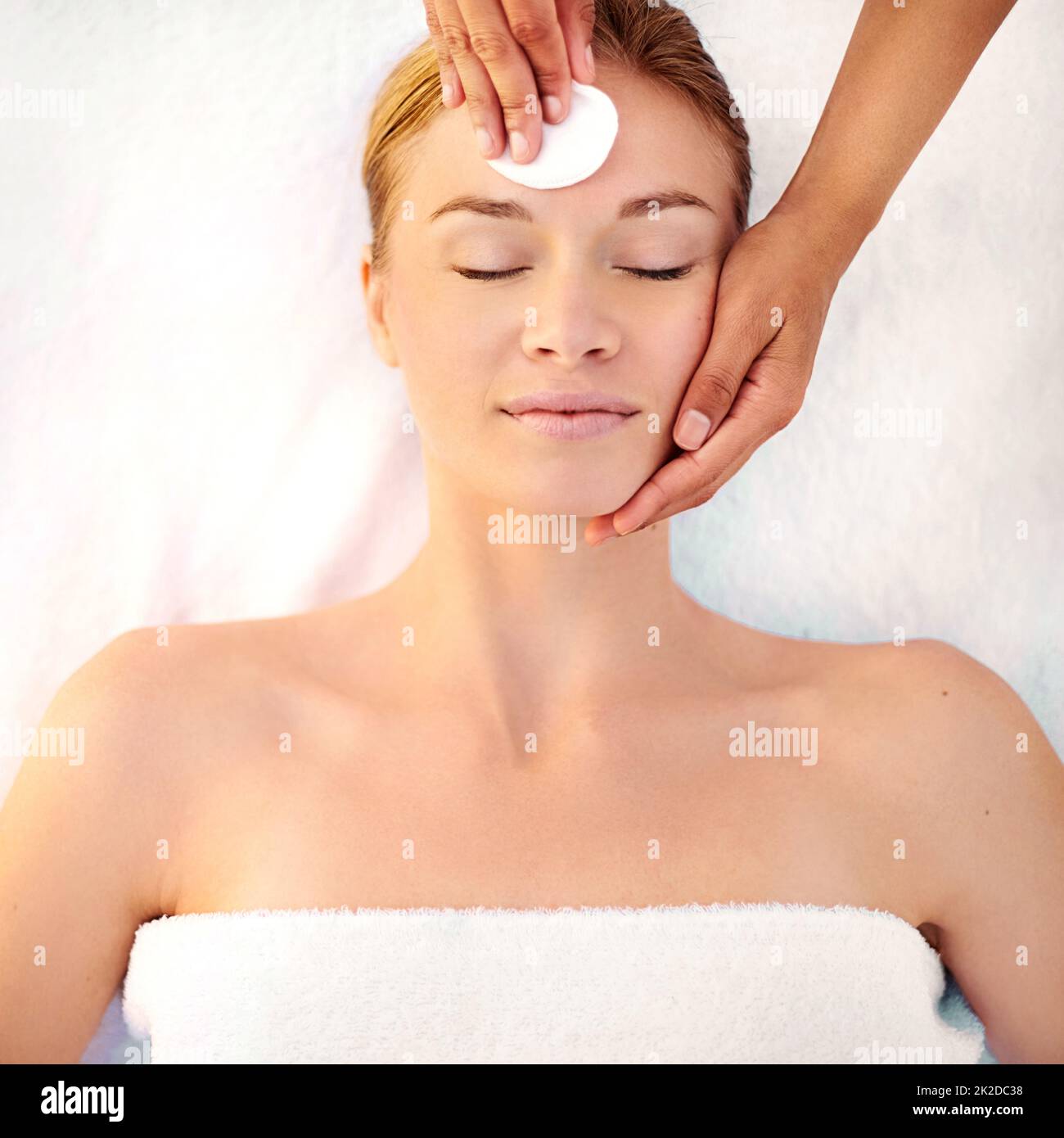 Starting her facial with a gentle cleanser. Shot of a young woman