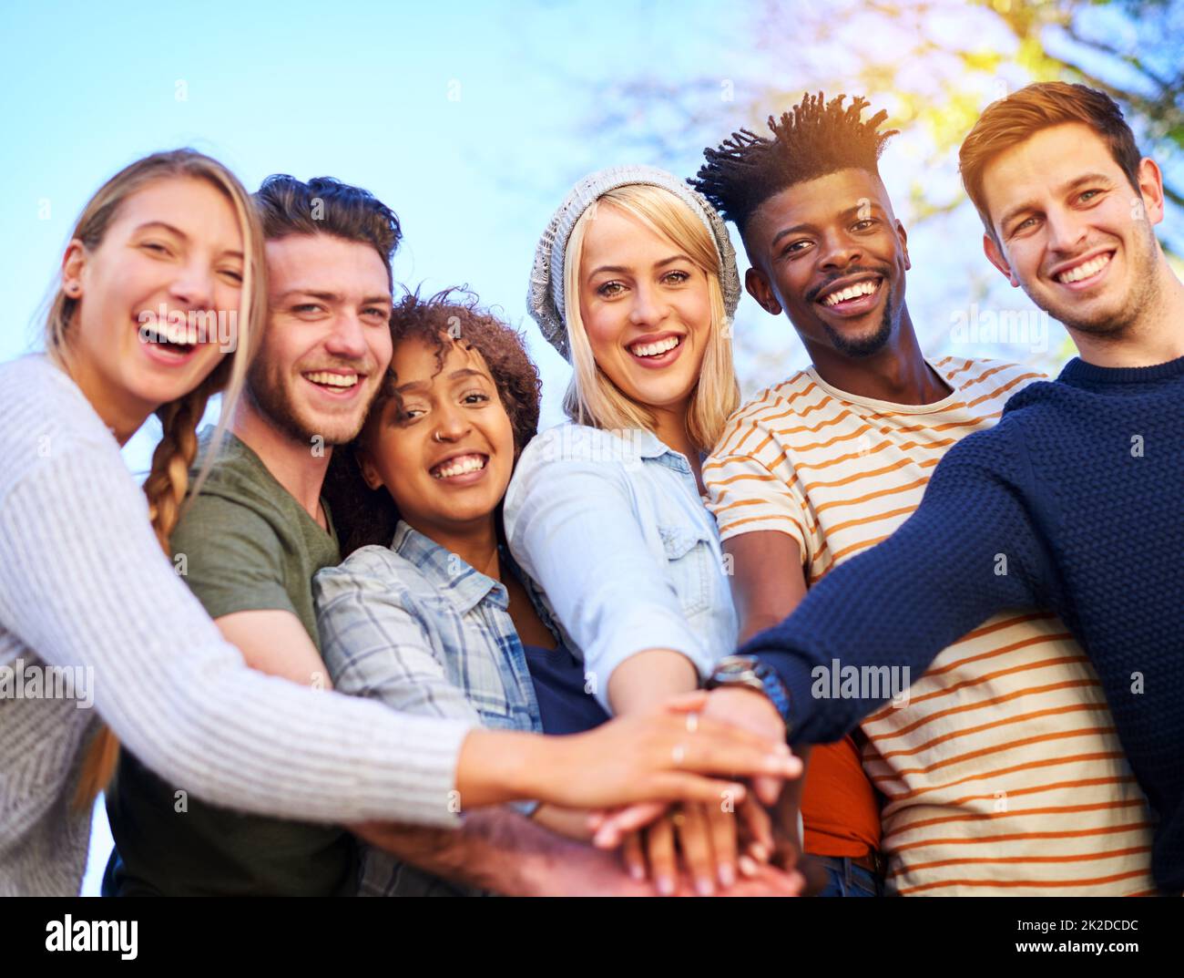 To becoming friends on campus. Cropped shot of a group of diverse students huddled together with their hands piled on top of each other. Stock Photo
