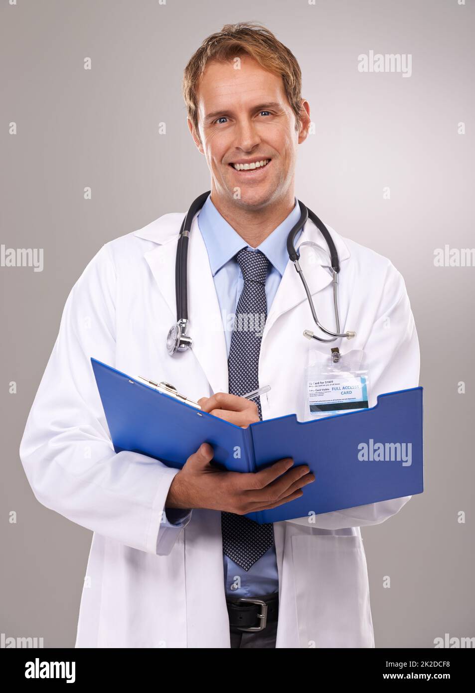 Treatment you can trust. Portrait of a smiling doctor writing in a patients chart. Stock Photo