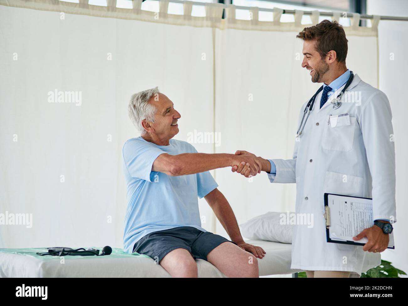 Looks like weve reached our goal. Cropped shot of a young male doctor shaking hands with an elderly patient in his office. Stock Photo