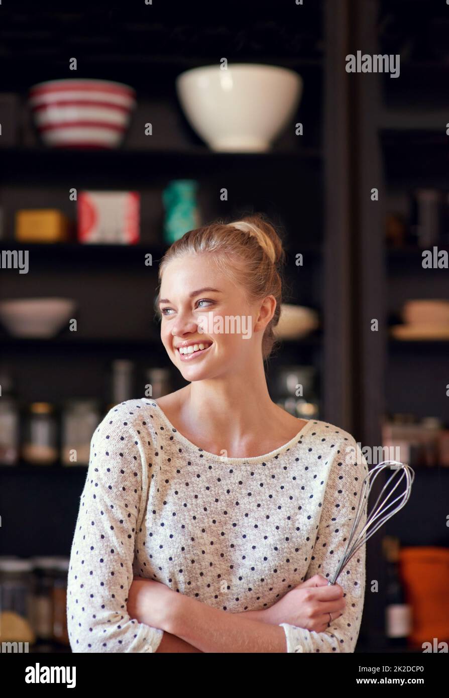 Whisked away.... Shot of a young woman standing with a whisk in her