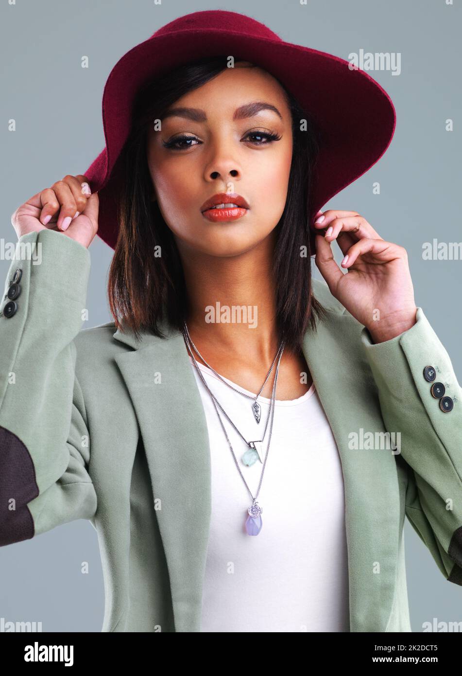 Fashions fade, style is eternal. Studio portrait of a stylish young woman posing against a gray background. Stock Photo