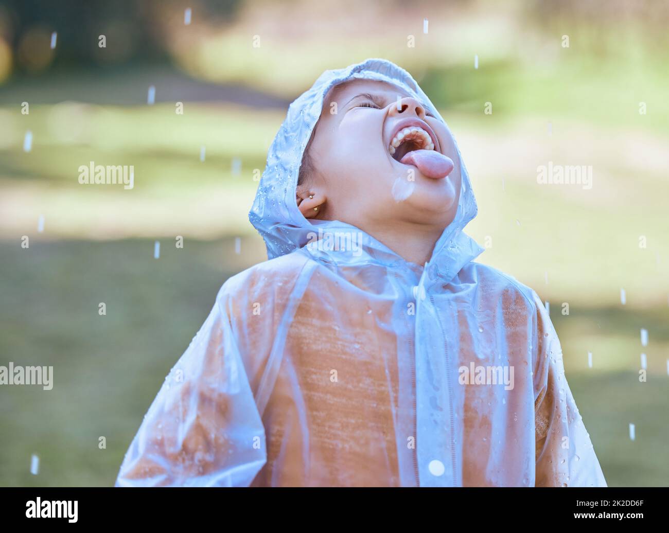 Like water from the heavens. Shot of a little girl sticking her tongue out to catch the rain