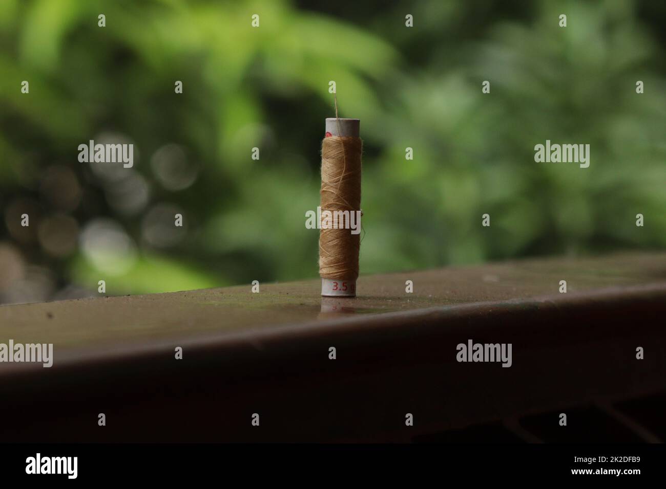 A sewing thread placed on a dusty floor Stock Photo - Alamy