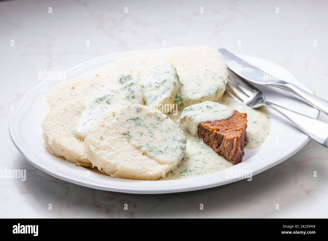 beef meat with dill sauce and dumplings Stock Photo