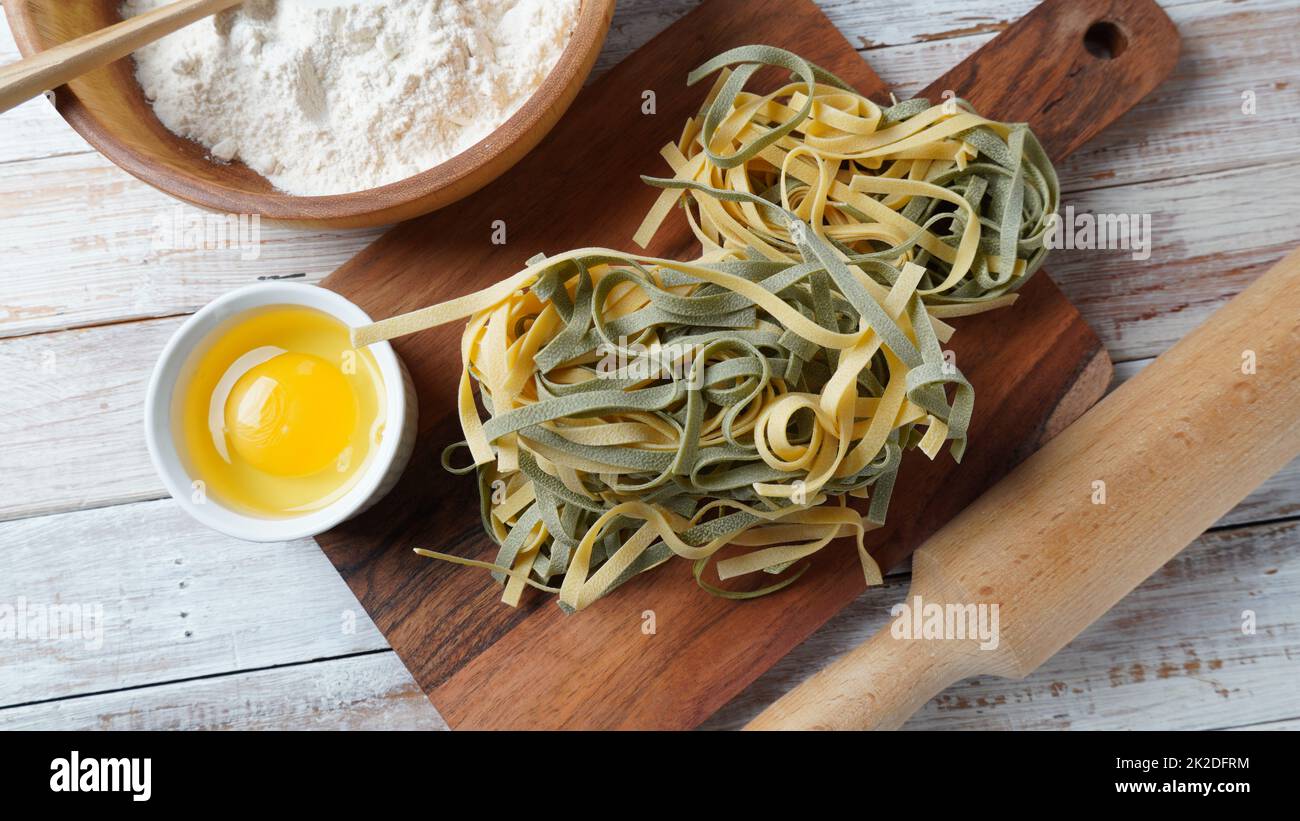 Uncooked Italian homemade egg pasta with spinach placed side by side Stock Photo