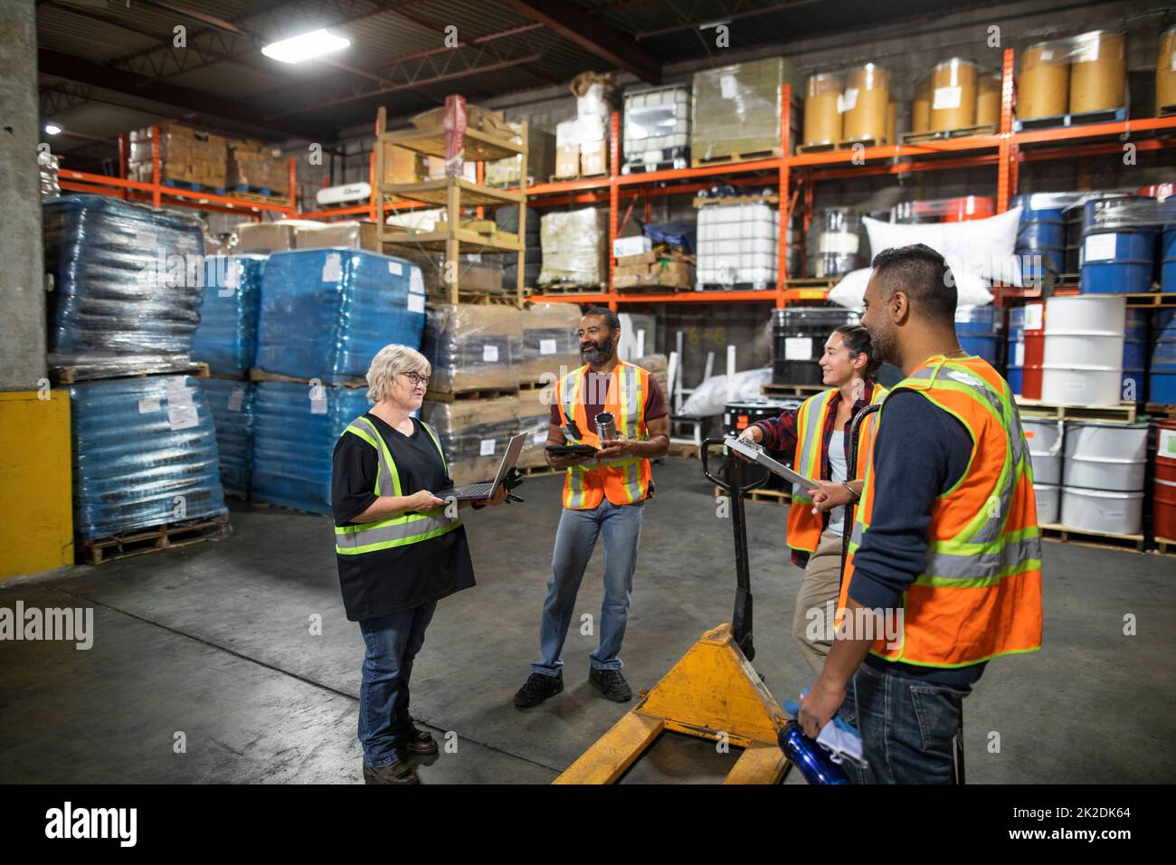Distribution warehouse owner and workers having team meeting Stock