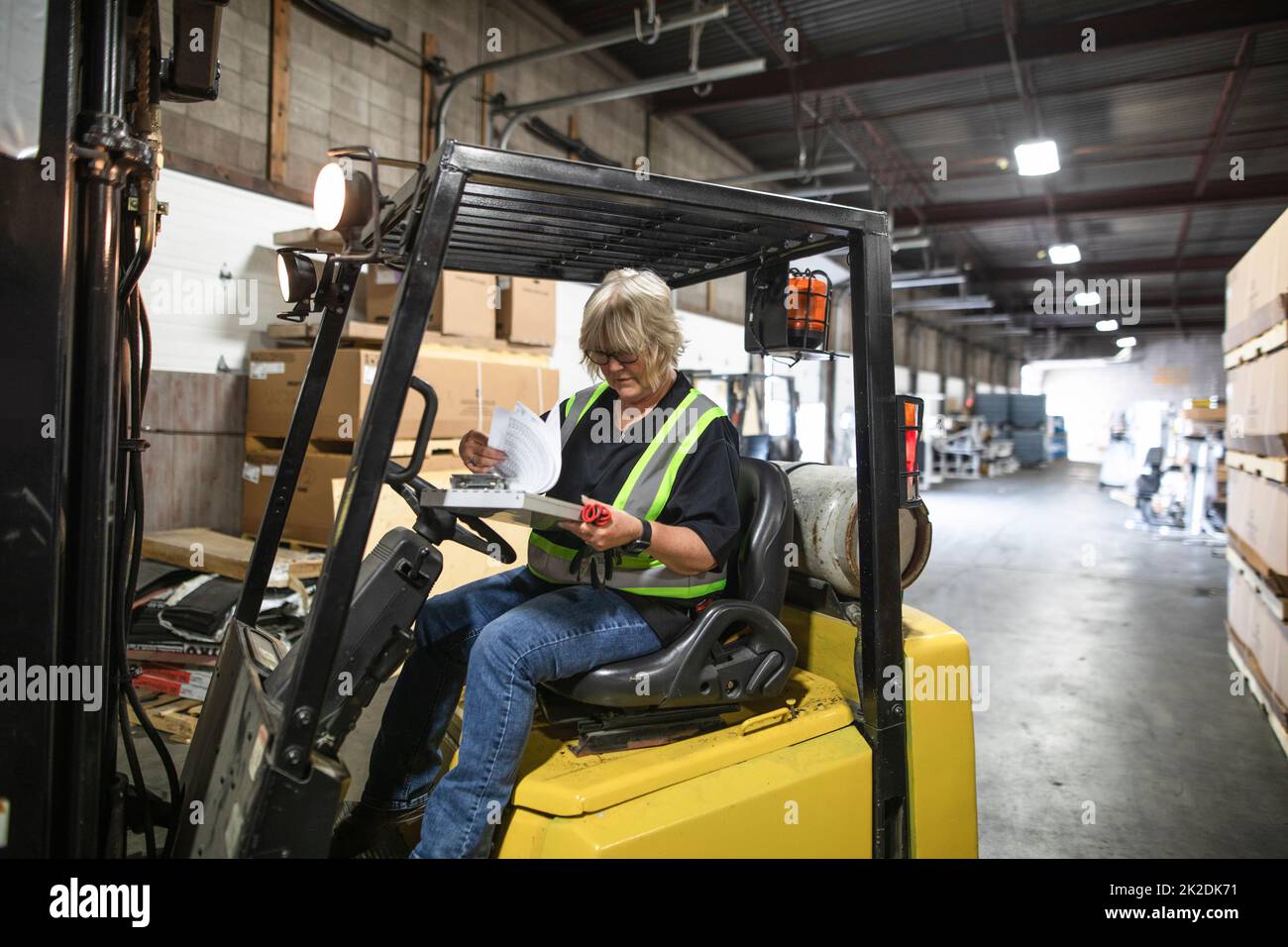 Warehouse owner doing paperwork in forklift Stock Photo Alamy