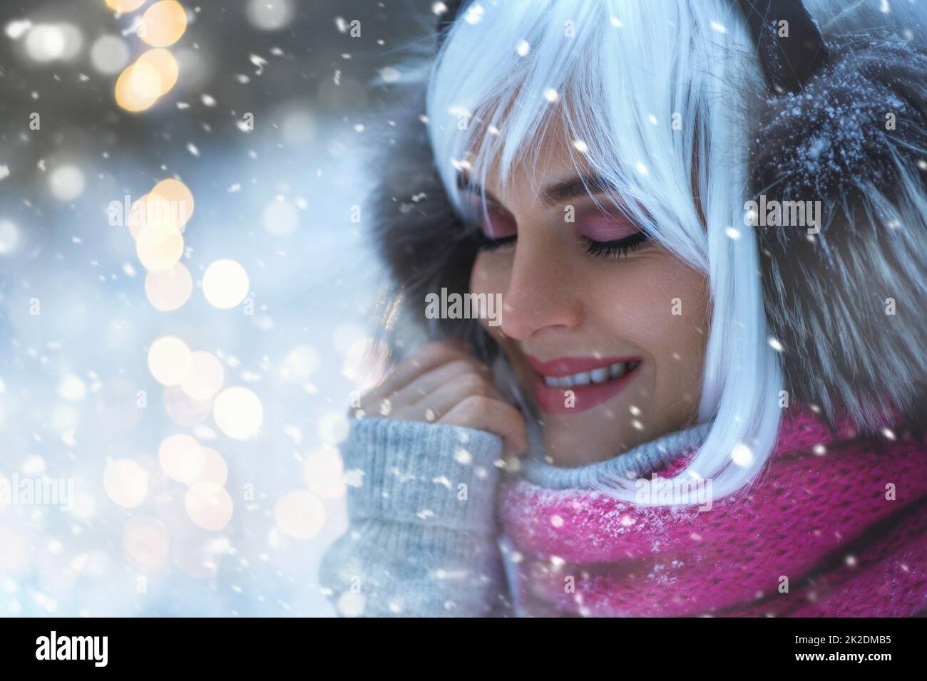 Young woman with white hair is walking in the snowy winter forest Stock Photo