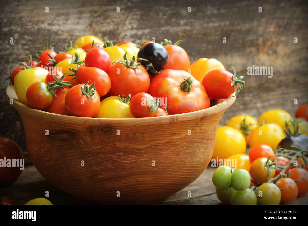 Wooden bowl with fresh vine ripened heirloom tomatoes from farmers market Stock Photo