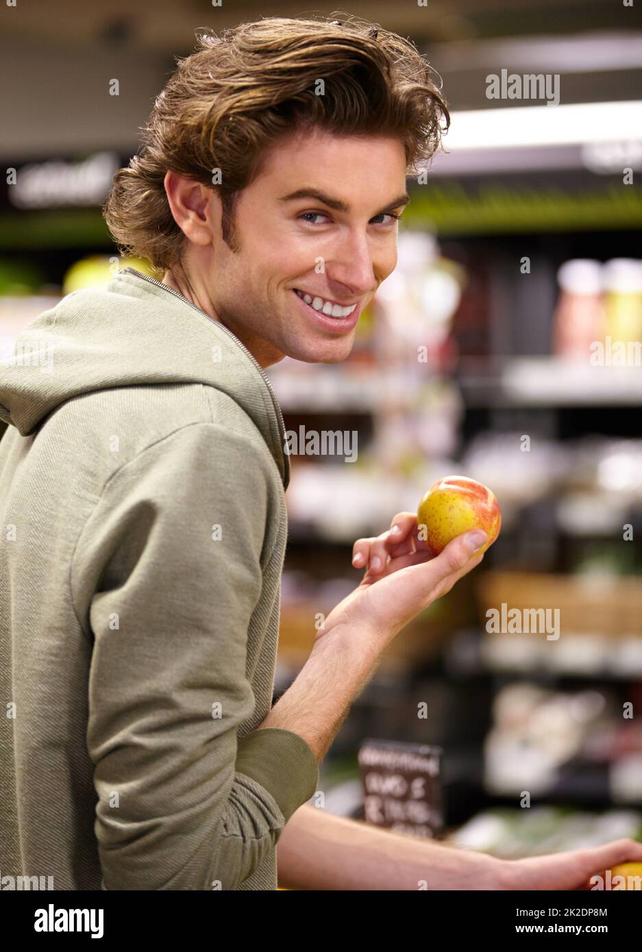 I want this one. A young man at the store buying fruit. Stock Photo