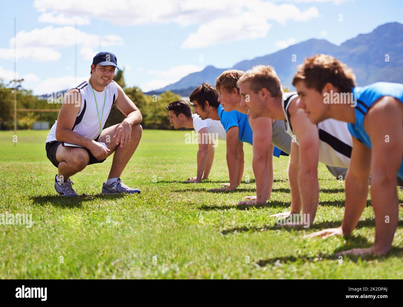 Whos the best. Young sportsmen training outdoors with a coach. Stock Photo