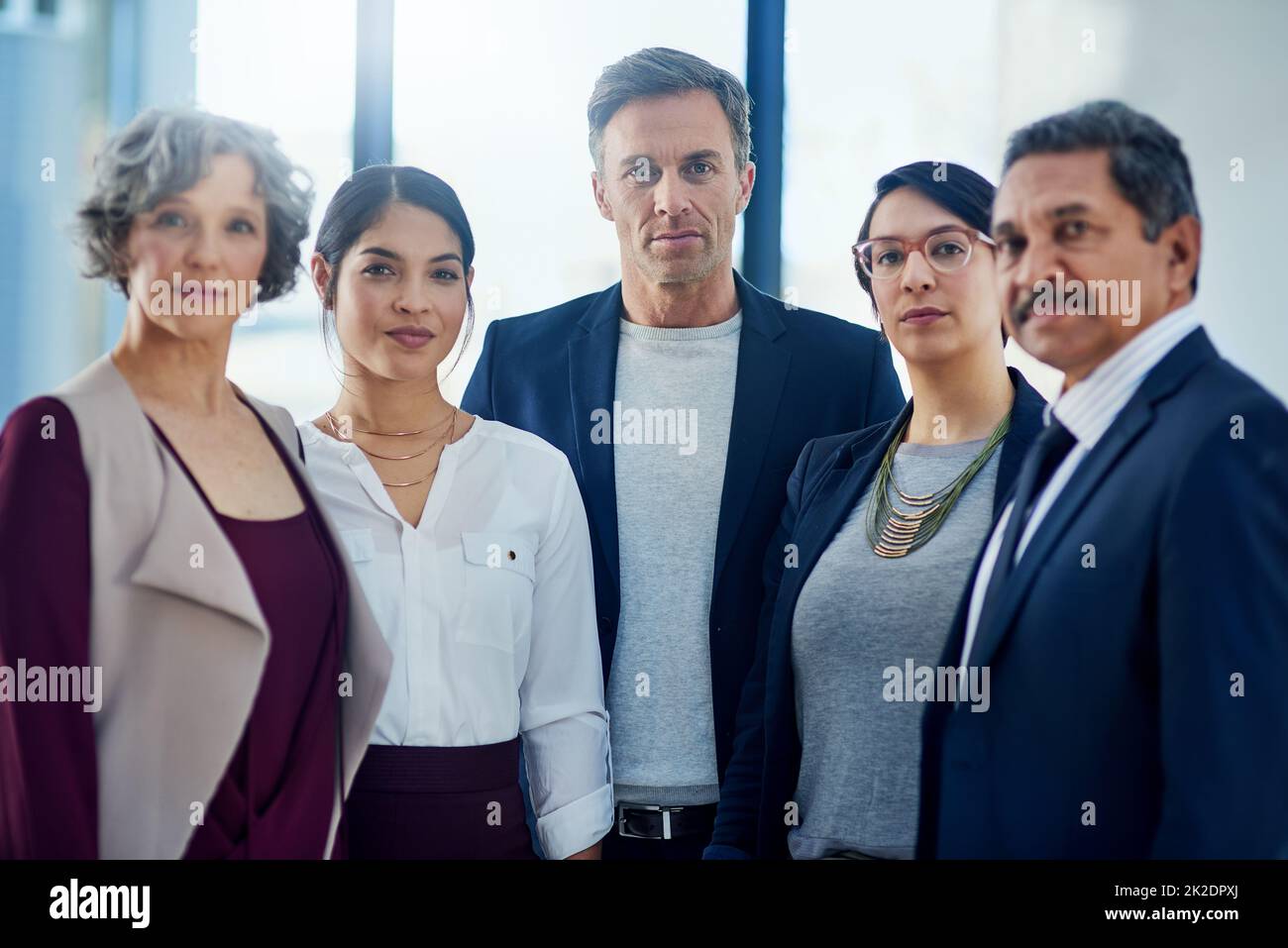 We dont wait for opportunities, we create them. Cropped portrait of a diverse group of businesspeople standing together in their office. Stock Photo