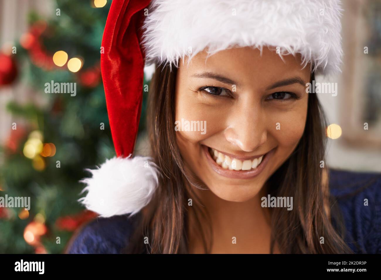 Looking forward to the festivites. Closeup shot of a beautiful woman wearing a santa hat. Stock Photo