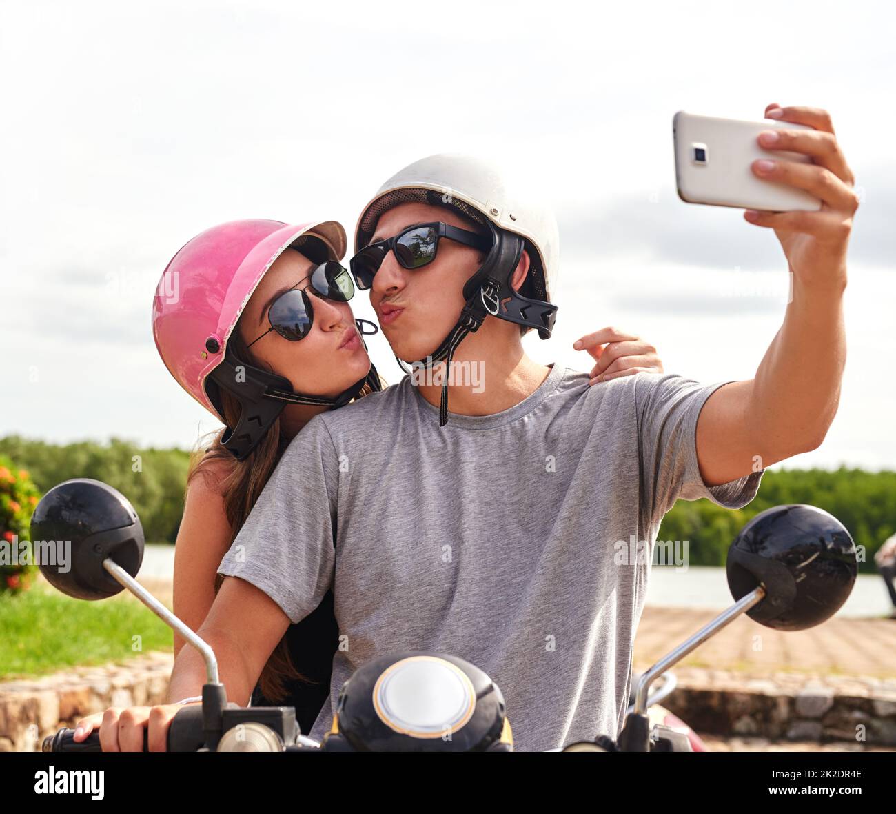 Making memories on the road. Shot of a young couple taking a selfie together while out for a ride on a scooter. Stock Photo