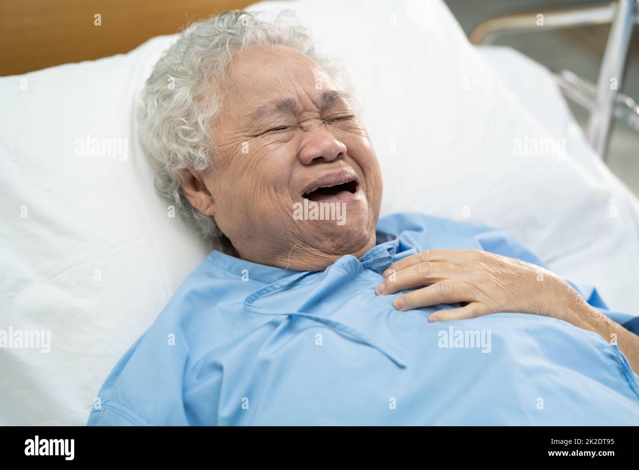 Asian senior or elderly old lady woman patient feel pain in the chest and heart on bed in nursing hospital ward  healthy strong medical concept. Stock Photo