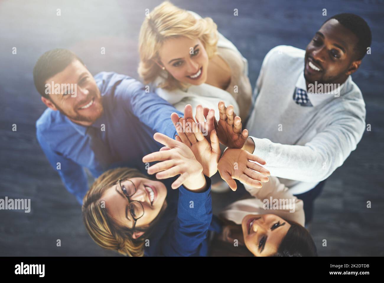 This team is going to the top. High angle shot of a group of businesspeople reaching for a high five. Stock Photo