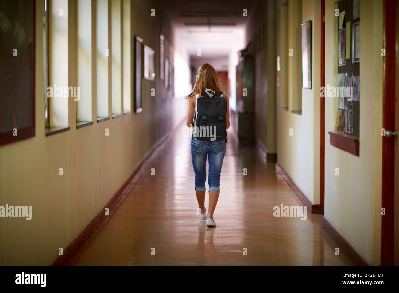 Time to go home. Shot of a young girl in her school hallway. Stock Photo