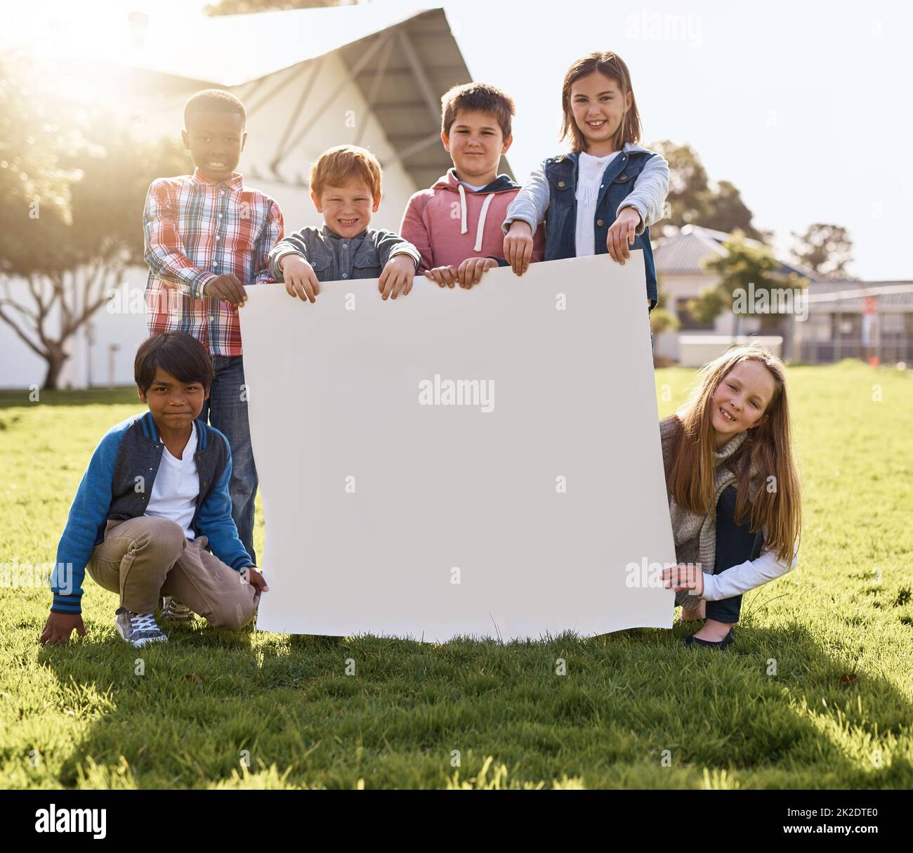 Holding up your message for their future. Shot of young kids playing together outdoors. Stock Photo