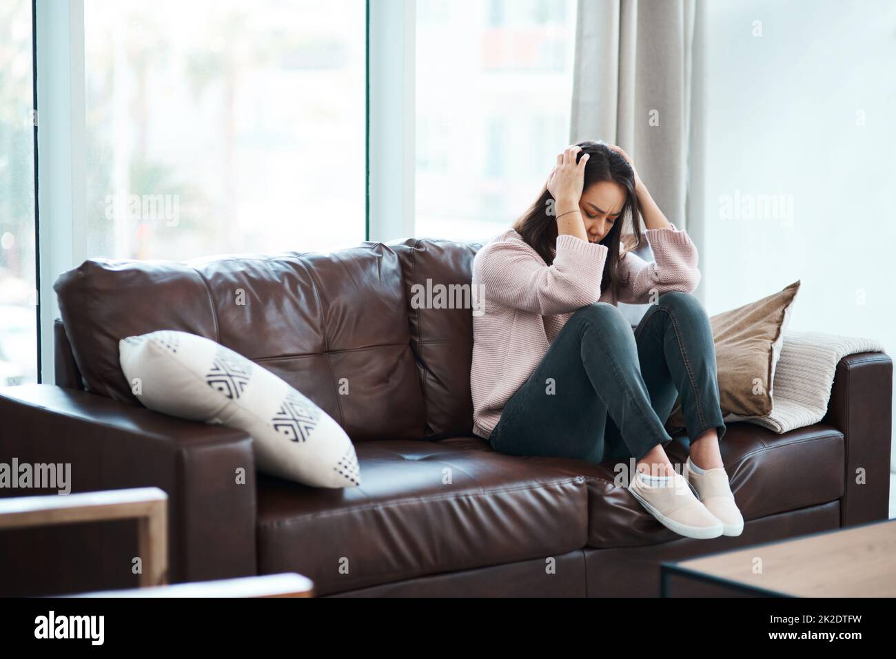 Its hard to fight the monster in your mind. Shot of a young woman experiencing mental anguish at home. Stock Photo