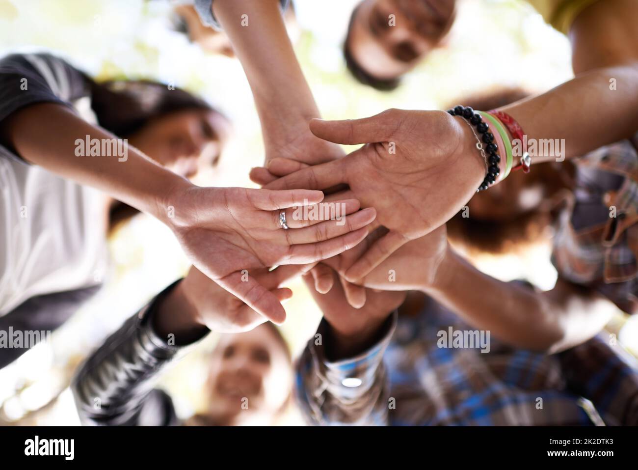 Three cheers for summer. A group of friends standing in a huddle with their hands piled. Stock Photo