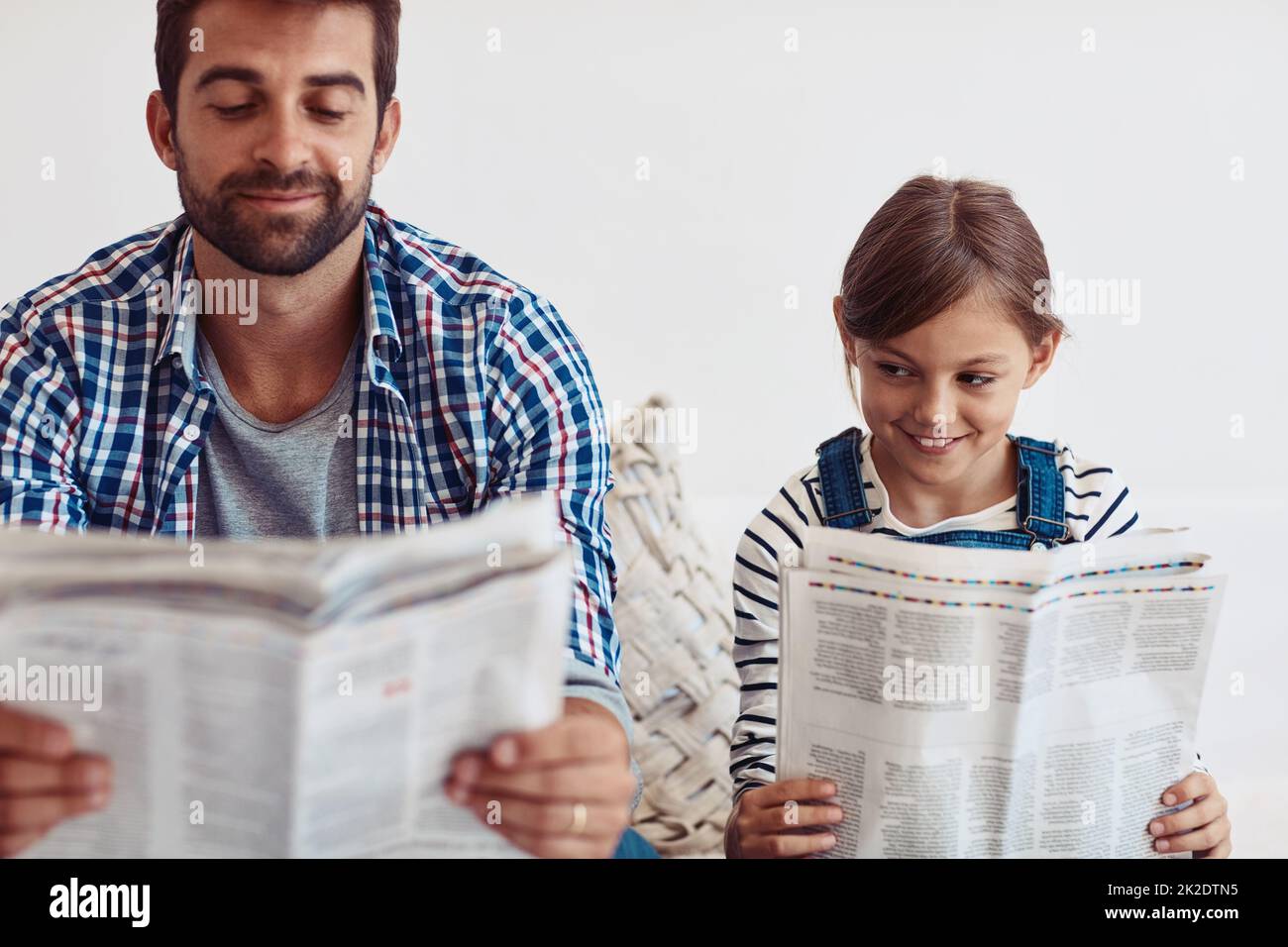 Well share some stories afterwards. Shot of an adorable little girl spending time with her father at home. Stock Photo