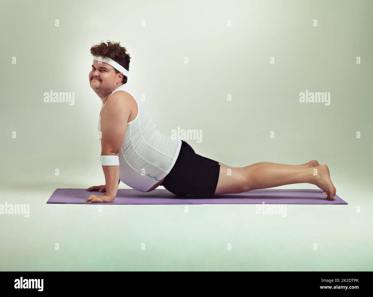 This upward facing dog pose is great. Shot of an overweight man doing yoga poses. Stock Photo