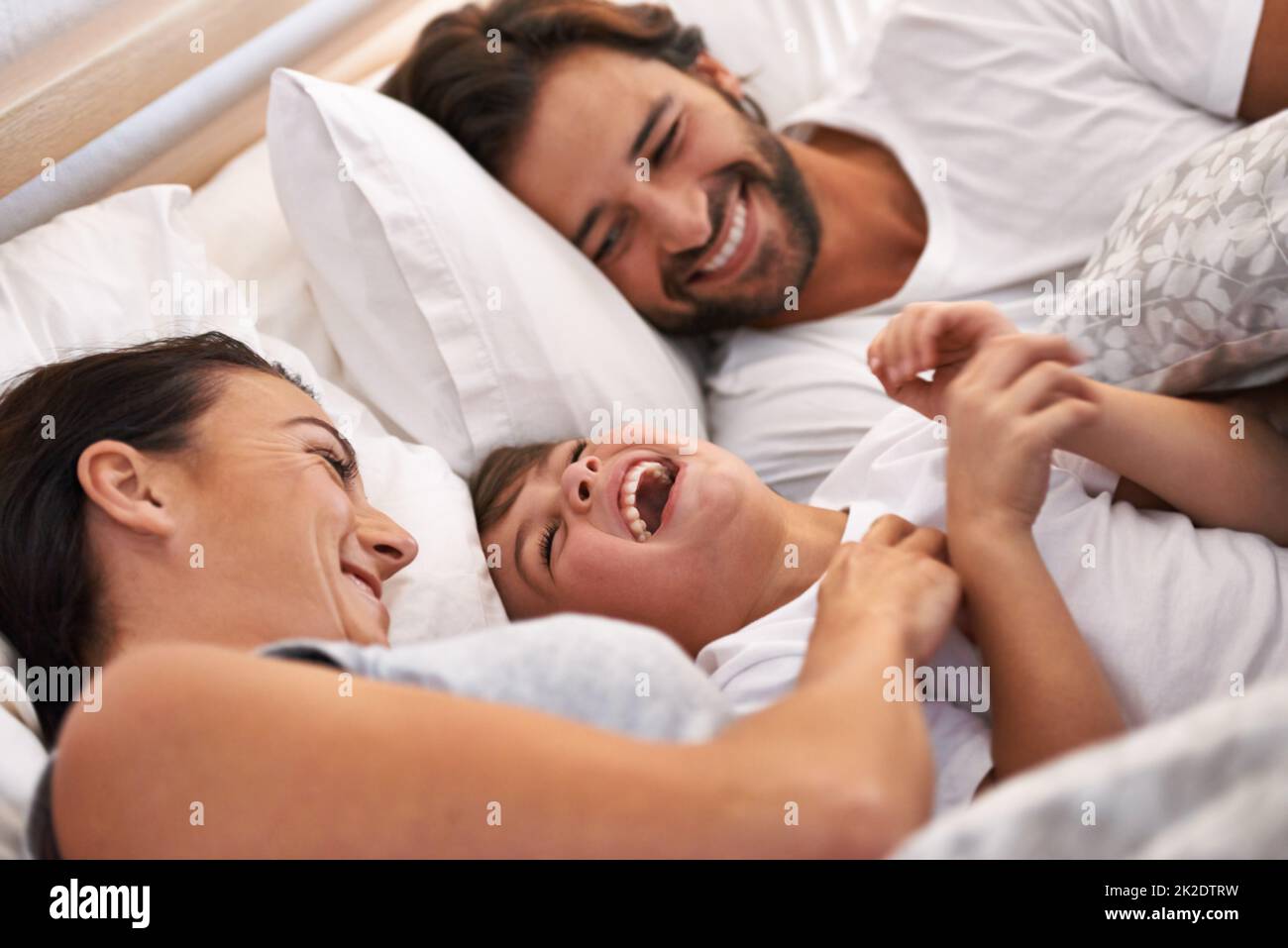 He always wants to be close to mommy and daddy. Cropped shot of a young family in bed together. Stock Photo