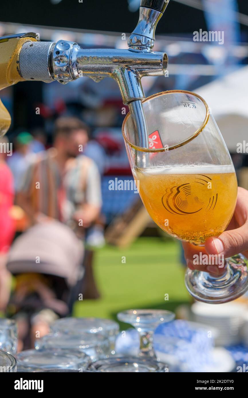 Beer pouring into glass in a bar, oktoberfest on sunny day, copy space. Stock Photo