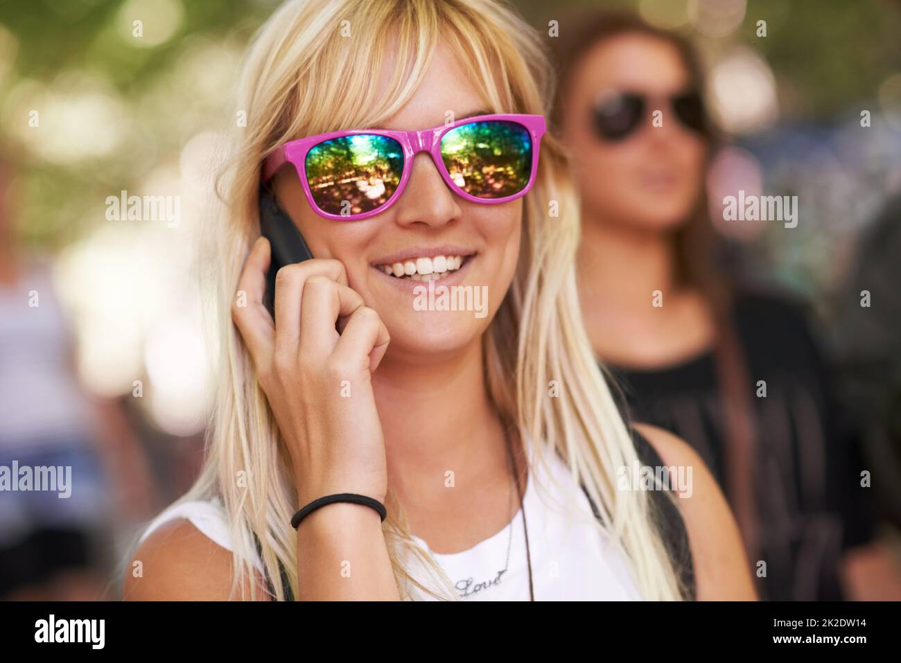 Trying to connect with friends at the festival. Shot of a young woman talking on a cellphone at an outdoor festival. Stock Photo