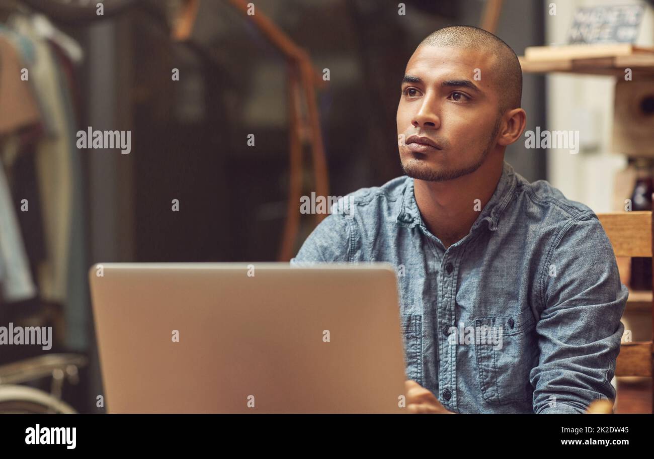 His store is wifi enabled. Shot of a young man using a laptop in a cafe. Stock Photo